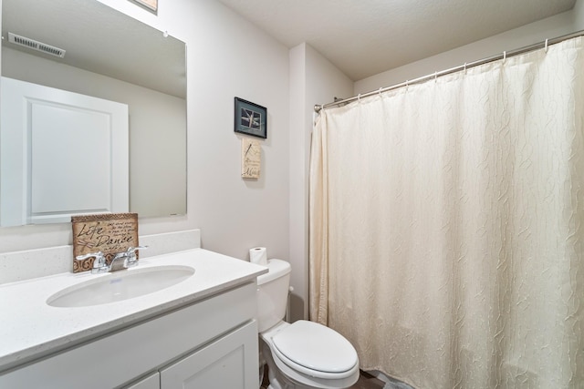 bathroom featuring visible vents, vanity, and toilet