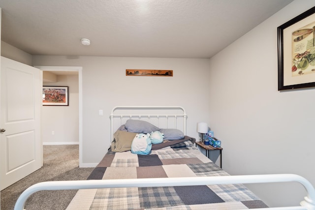 carpeted bedroom with a textured ceiling and baseboards