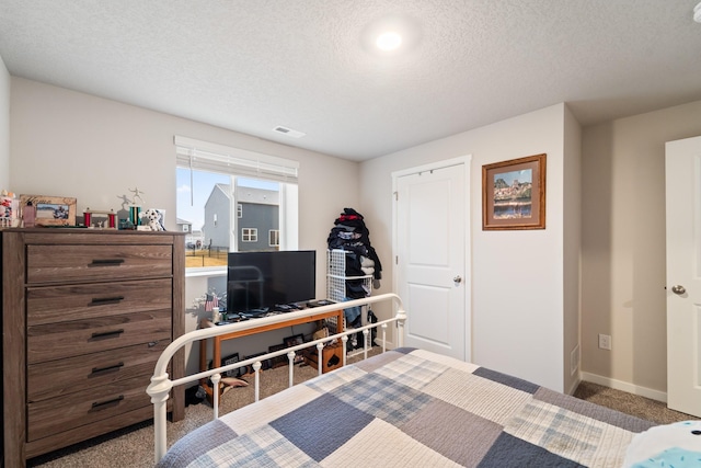 bedroom featuring baseboards, carpet, visible vents, and a textured ceiling