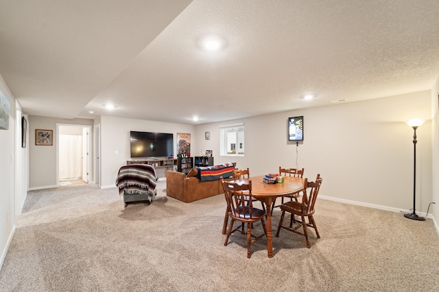 dining room with recessed lighting, baseboards, a textured ceiling, and light colored carpet