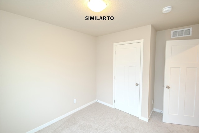 unfurnished bedroom featuring a closet, carpet flooring, visible vents, and baseboards