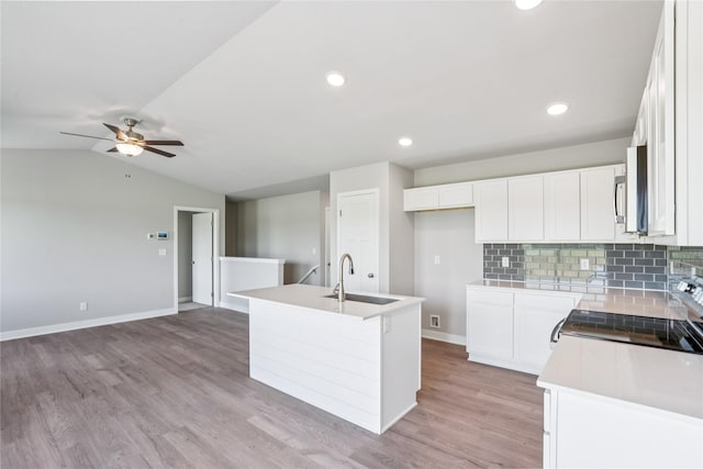 25091 Bluebird Cir, Adel, IA 50003 - kitchen with range with electric cooktop, open floor plan, decorative backsplash, white cabinetry, and lofted ceiling