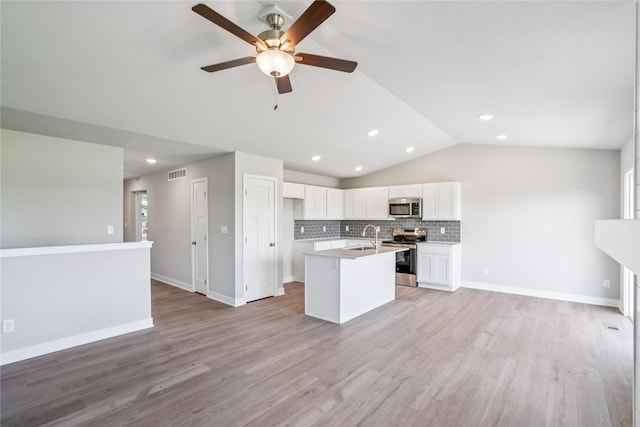 25091 Bluebird Cir, Adel, IA 50003 - kitchen featuring stainless steel appliances, open floor plan, vaulted ceiling, decorative backsplash, and ceiling fan