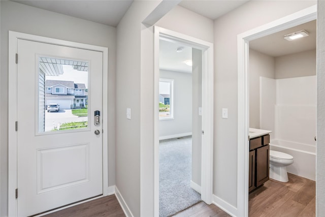 25091 Bluebird Cir, Adel, IA 50003 - doorway featuring light wood-type flooring and baseboards