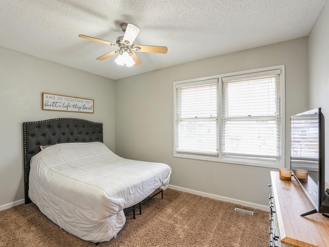 bedroom featuring carpet, visible vents, a textured ceiling, and baseboards