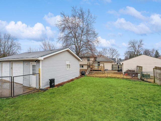 exterior space with a detached garage, fence, and an outbuilding