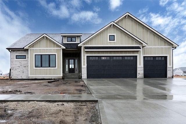 view of front of home featuring an attached garage, a shingled roof, board and batten siding, and concrete driveway