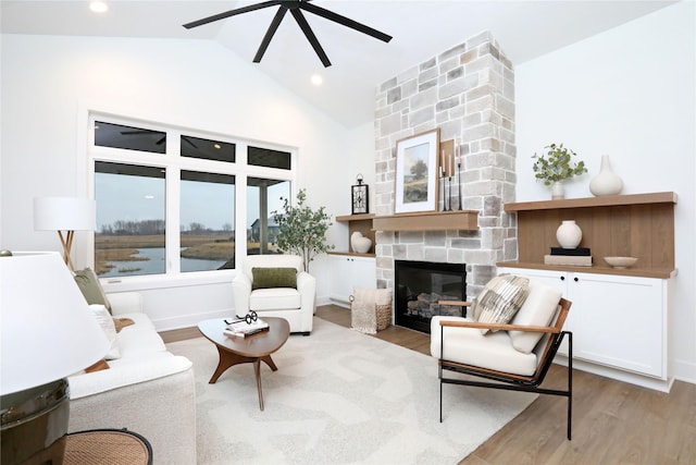 living area with a ceiling fan, wood finished floors, vaulted ceiling, a fireplace, and recessed lighting