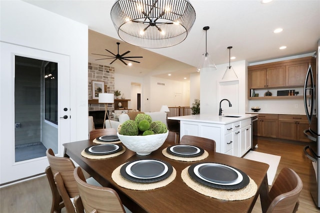 dining space featuring ceiling fan with notable chandelier, light wood-type flooring, and recessed lighting