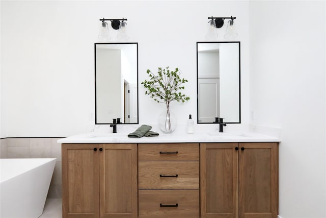 bathroom with a freestanding tub, a sink, and double vanity