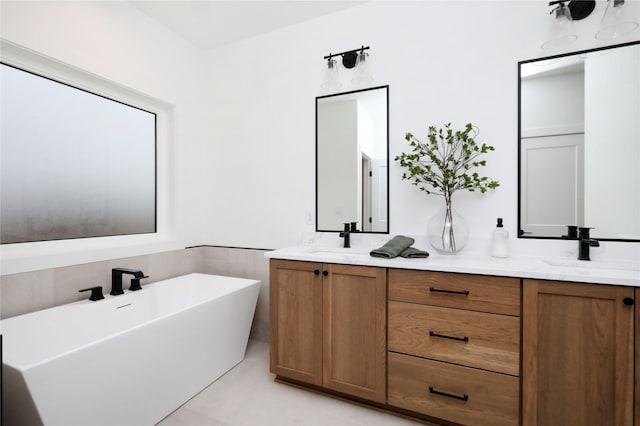 bathroom featuring double vanity, a freestanding bath, and a sink