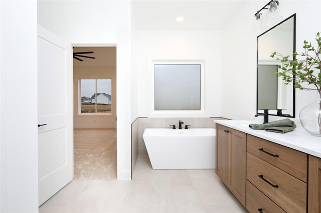 full bathroom featuring a soaking tub and vanity