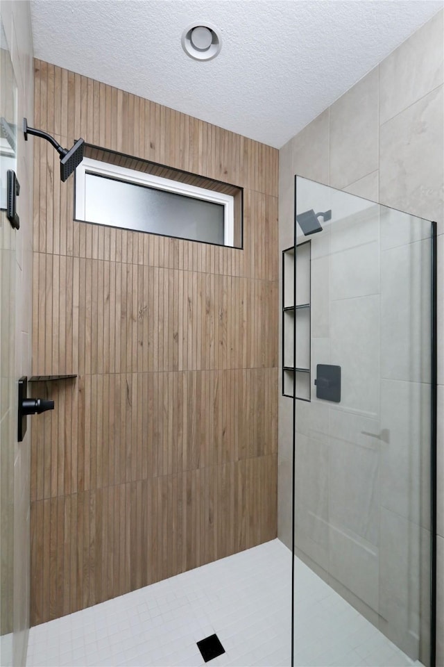 bathroom with a textured ceiling and walk in shower