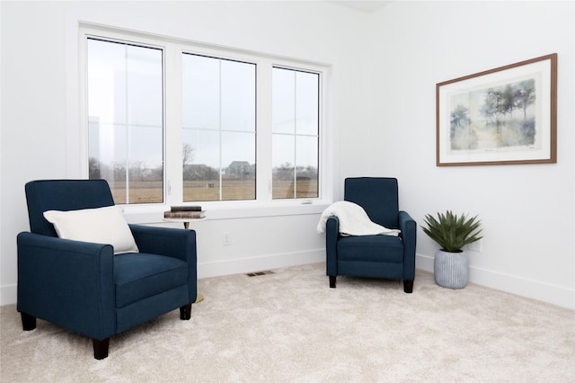 sitting room featuring carpet flooring and baseboards