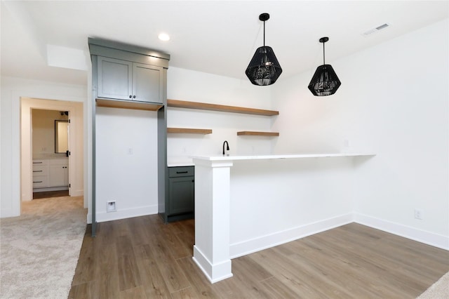 kitchen with wood finished floors, visible vents, baseboards, gray cabinets, and open shelves