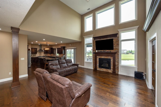 1306 NE 45th St, Ankeny, IA 50021 - living area with dark wood-type flooring, a fireplace, decorative columns, a towering ceiling, and baseboards