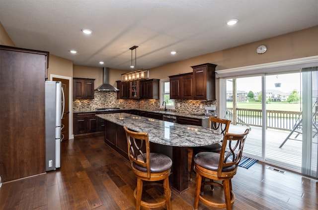 1306 NE 45th St, Ankeny, IA 50021 - kitchen with wall chimney exhaust hood, stainless steel appliances, a sink, a kitchen island, and dark brown cabinetry