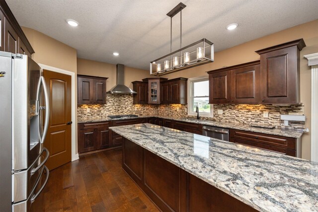 1306 NE 45th St, Ankeny, IA 50021 - kitchen with stainless steel appliances, wall chimney range hood, a sink, dark brown cabinets, and dark wood-type flooring