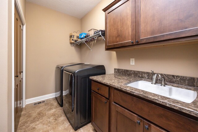 1306 NE 45th St, Ankeny, IA 50021 - laundry area with washer and clothes dryer, cabinet space, baseboards, and a textured ceiling
