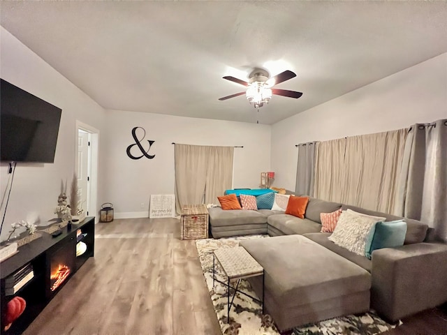 living room with baseboards, a ceiling fan, and wood finished floors