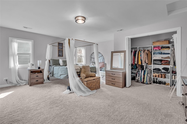 carpeted bedroom with visible vents and a closet