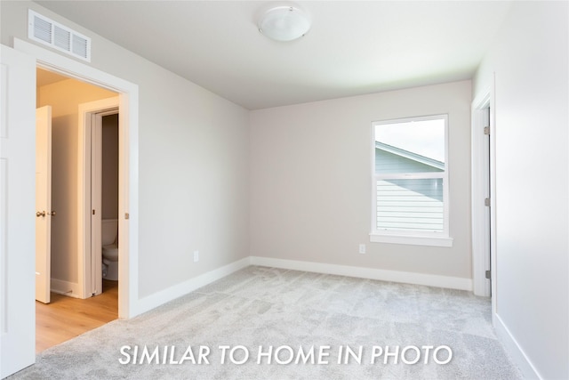 spare room featuring carpet flooring, visible vents, and baseboards