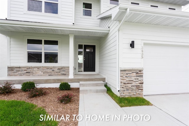 property entrance with an attached garage, stone siding, and covered porch