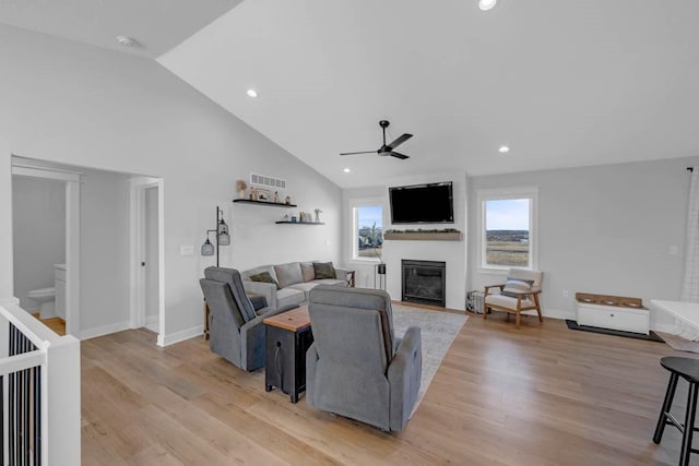 living area featuring visible vents, a glass covered fireplace, light wood-style flooring, ceiling fan, and recessed lighting