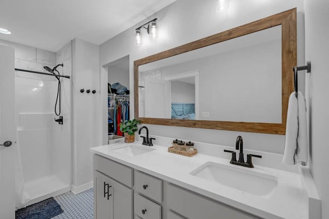 full bathroom featuring a stall shower, a walk in closet, a sink, and double vanity