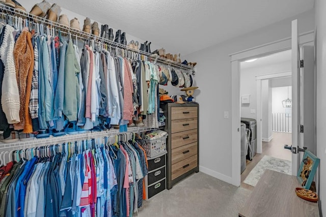 walk in closet featuring light colored carpet