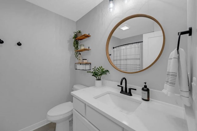 bathroom featuring toilet, baseboards, and vanity