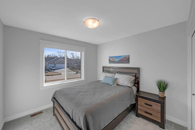 bedroom featuring baseboards, visible vents, and light colored carpet