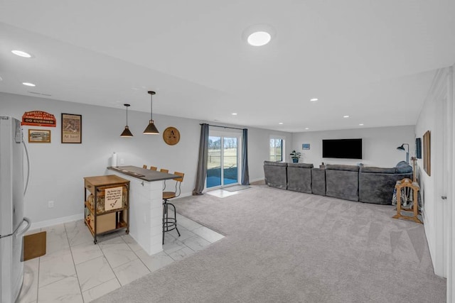 kitchen featuring baseboards, freestanding refrigerator, marble finish floor, pendant lighting, and recessed lighting