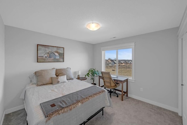 bedroom with light carpet and baseboards