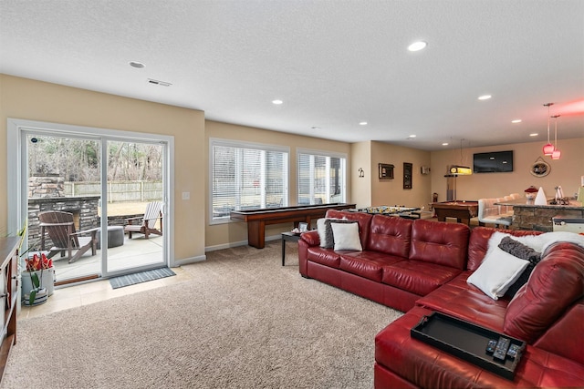 carpeted living area with baseboards, visible vents, a textured ceiling, and recessed lighting