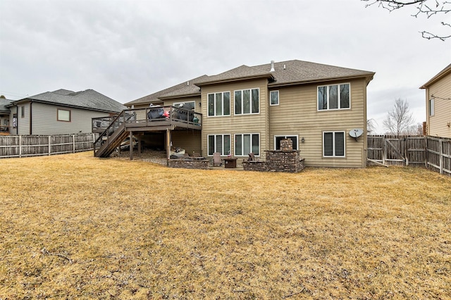 rear view of house with a fenced backyard, stairs, a lawn, and a wooden deck