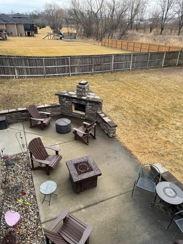 view of patio / terrace featuring an outdoor fire pit, exterior fireplace, and a fenced backyard