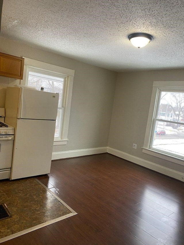 interior space with dark wood-style floors, a textured ceiling, and baseboards