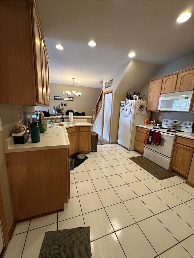 kitchen with white appliances, a peninsula, an inviting chandelier, light countertops, and recessed lighting