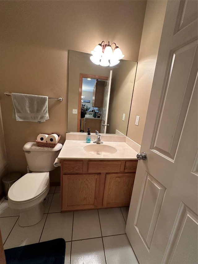 half bath with toilet, vanity, and tile patterned floors