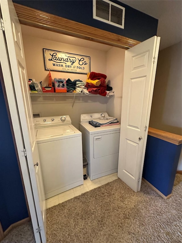 laundry area featuring light tile patterned floors, visible vents, light carpet, washer and dryer, and laundry area