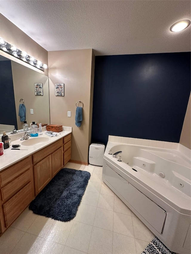 full bath with a whirlpool tub, tile patterned floors, a textured ceiling, and vanity