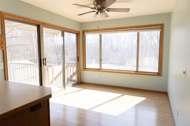 unfurnished sunroom with a ceiling fan