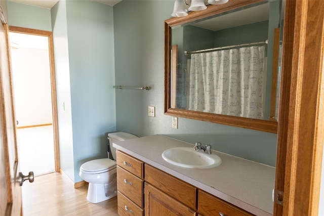 bathroom with wood finished floors, a shower with shower curtain, vanity, and toilet