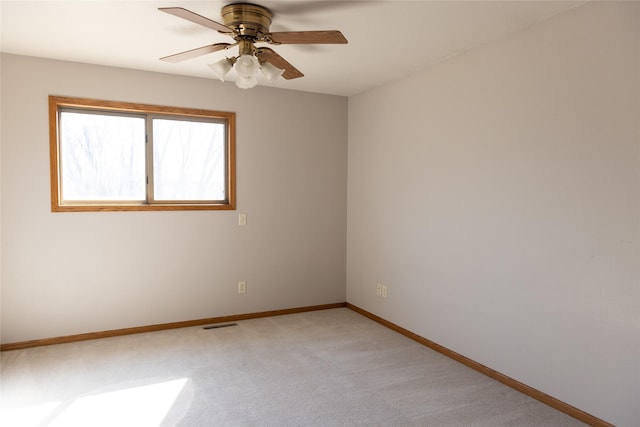 spare room with visible vents, baseboards, a ceiling fan, and light colored carpet