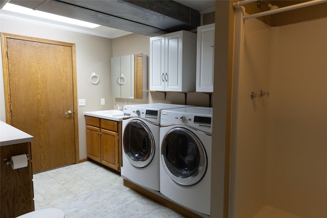 laundry area with cabinet space, washing machine and dryer, and a sink