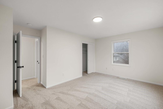 unfurnished bedroom featuring baseboards, carpet floors, and a closet