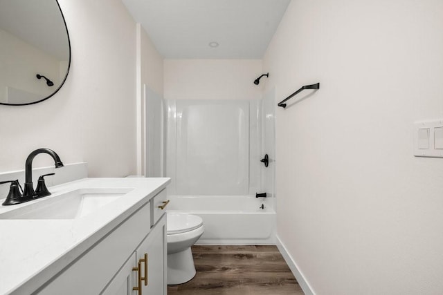 bathroom with shower / bathing tub combination, wood finished floors, toilet, and vanity