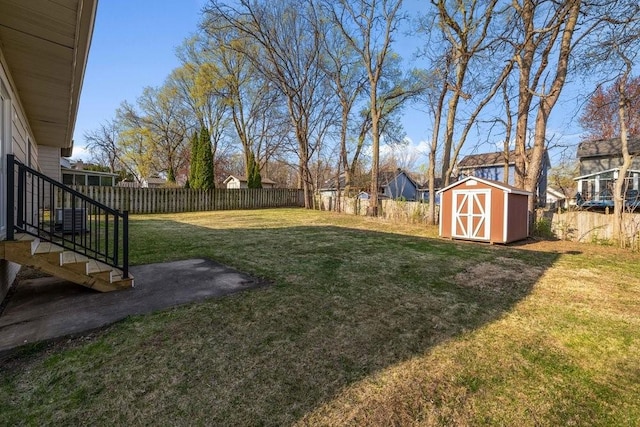 view of yard with an outdoor structure, a shed, and a fenced backyard