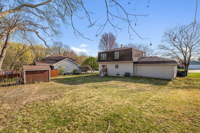 view of yard with an outdoor structure, central AC unit, and a shed